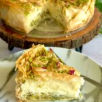 Baklava cheesecake served on a wooden serving platter with a slice served in a plate