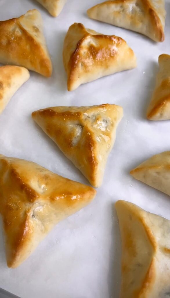  Removing the golden-baked spinach pies from the oven, looking irresistibly delicious.
