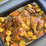 Golden, crispy roasted chicken flattened for even cooking, surrounded by perfectly caramelized potatoes and carrots, seasoned with a blend of aromatic spices and herbs. A mouthwatering one-pan dinner ready to impress!