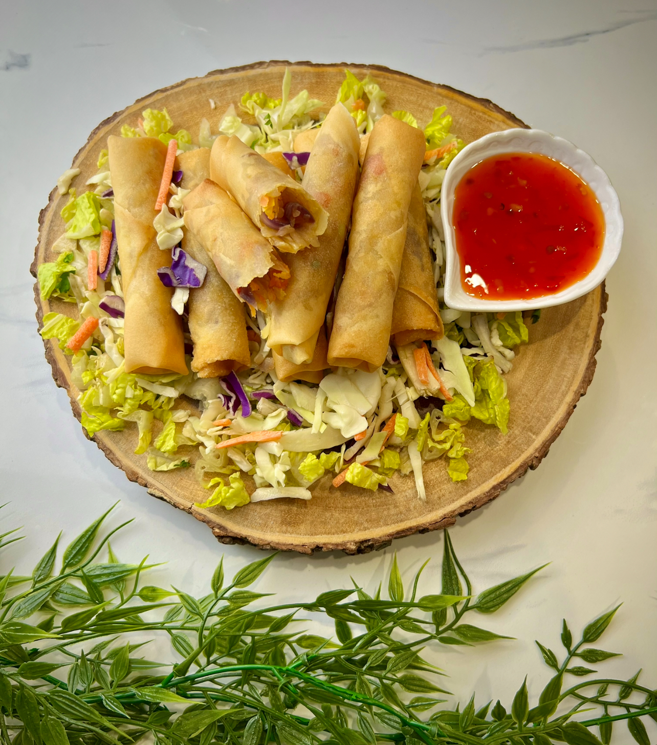 Fresh vegetable spring rolls filled with colorful vegetables, served with a side of dipping sauce.”