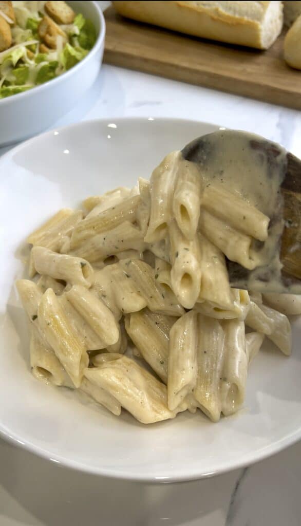 “A plate of creamy Boursin pasta, garnished with fresh herbs and ready to serve.”