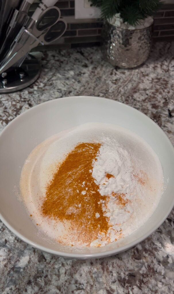 Dry ingredients for the  cake: flour, semolina, sugar, baking powder, and turmeric in a bowl.