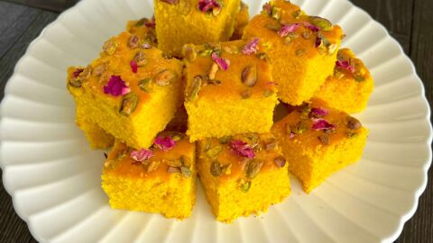 Golden Sfouf turmeric cake with pistachios and pine nuts on top.