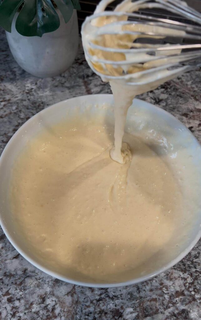 Mixing waffle batter ingredients in a bowl.
