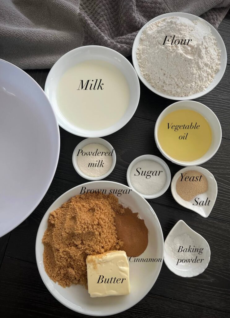 A collection of ingredients , including flour, sugar, butter, yeast, milk, and eggs.