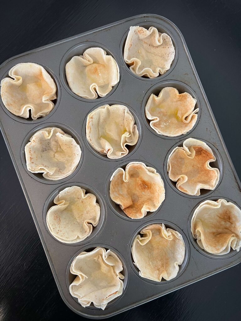 Place each bread circle inside the muffin pan.
