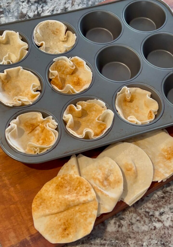 Place each bread circle inside the muffin pan.
