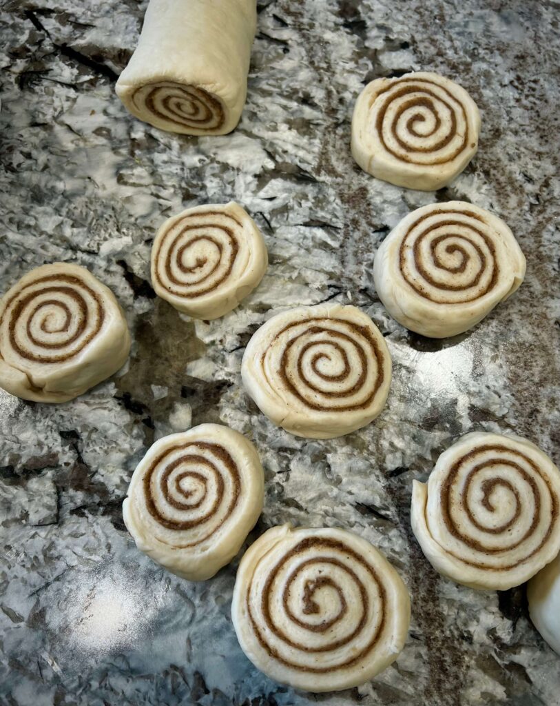 Cinnamon dough rolled up and sliced into pieces for baking.