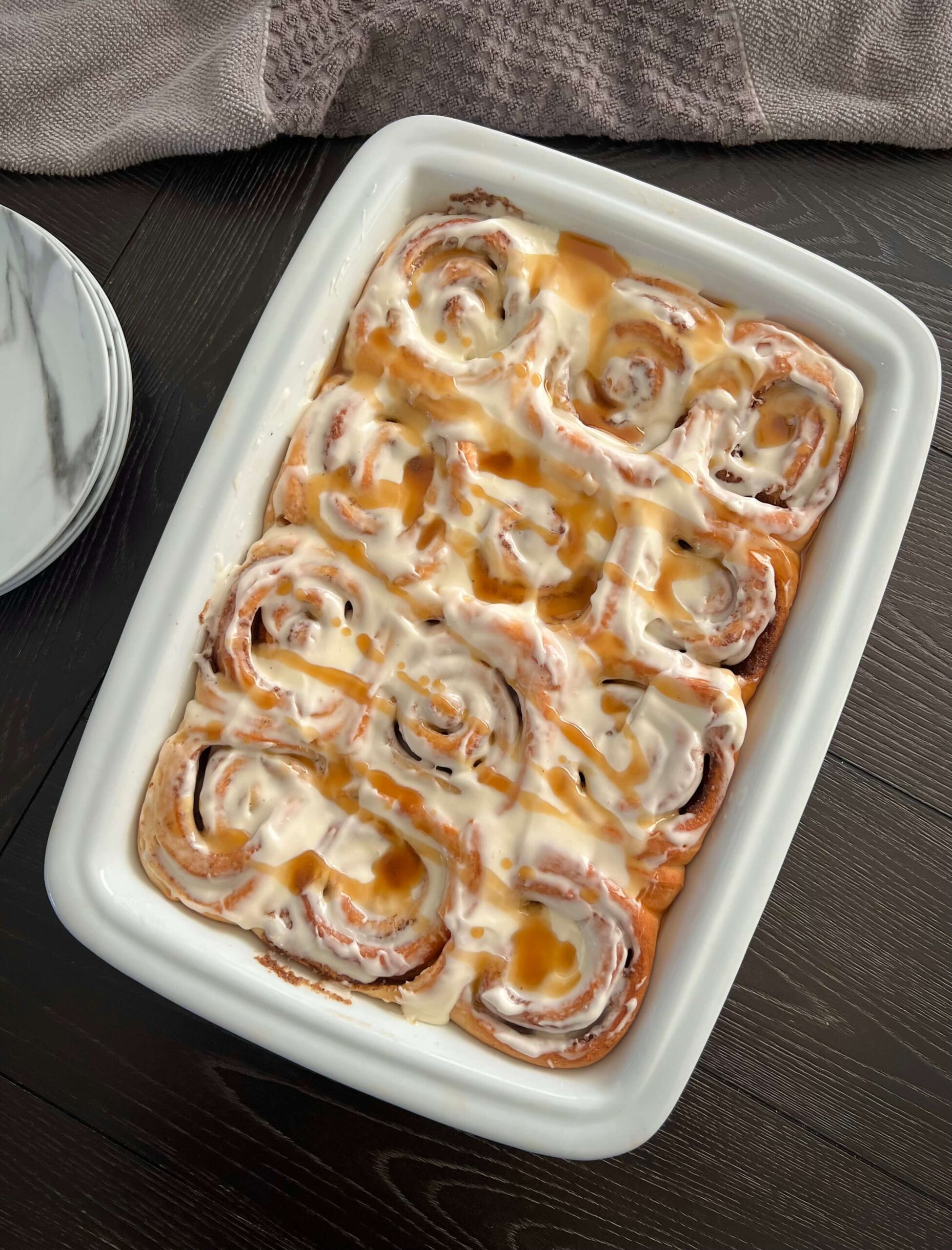 Freshly baked cinnamon rolls topped with icing.