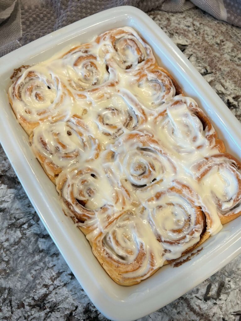 Freshly baked cinnamon rolls topped with icing.