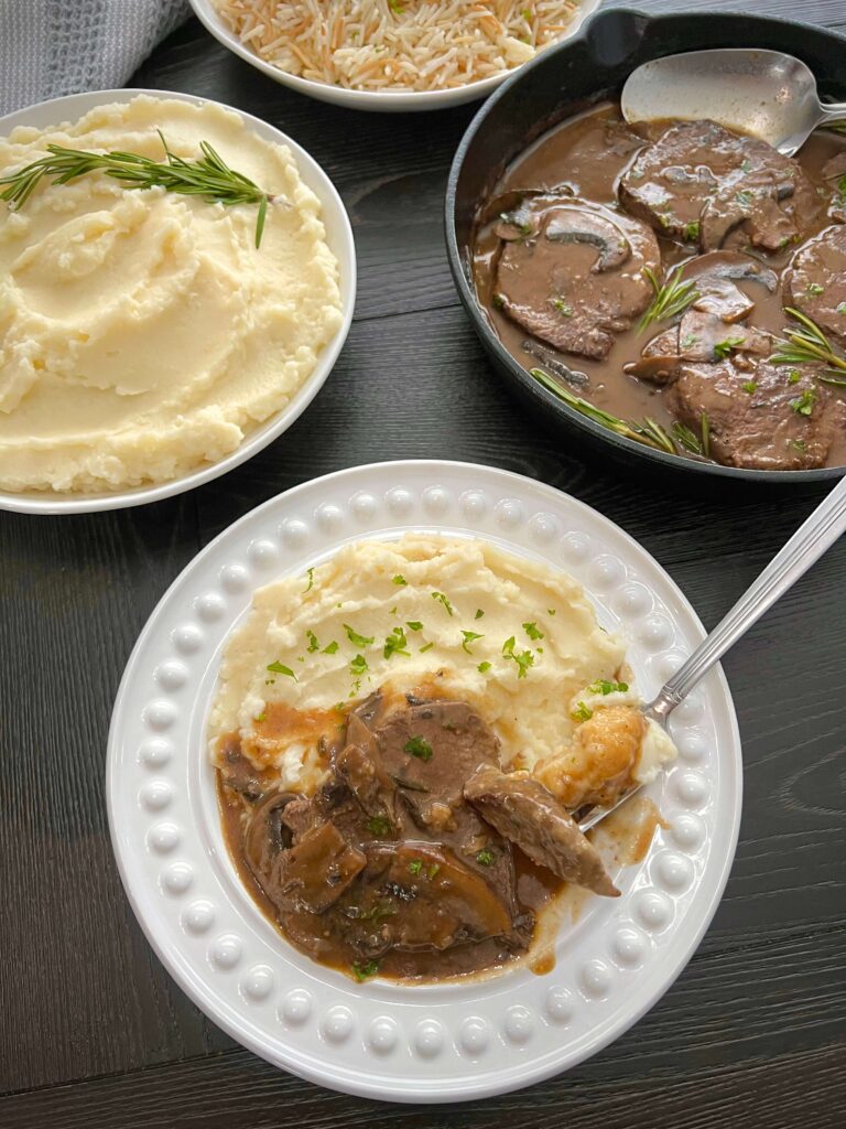 Serve the steak with mushroom gravy over mashed potato 