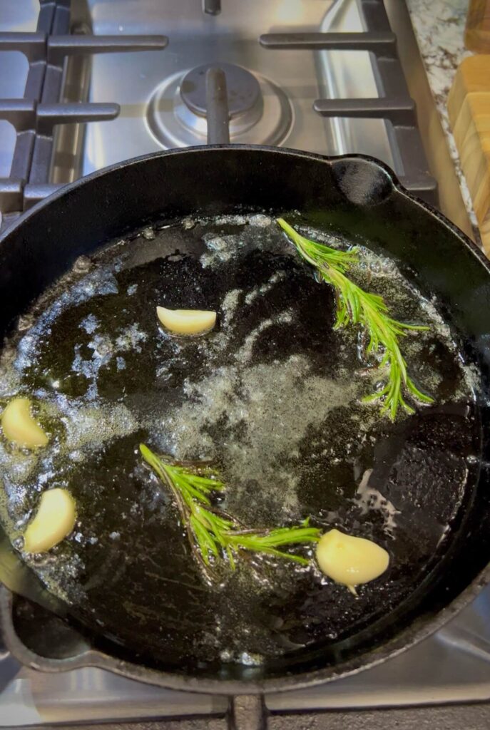 Heat olive oil and butter in a skillet, adding garlic and rosemary to infuse the oil.