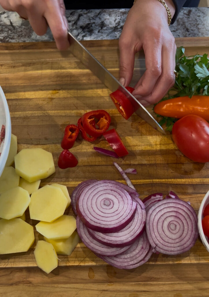 Slice the vegetables for Kafta bil sanieh 