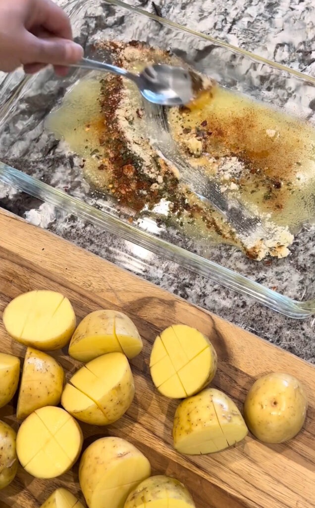 Cutting the potatoes in half then mix the spices and add the potatoes on top the Parmesan cheese and spices 