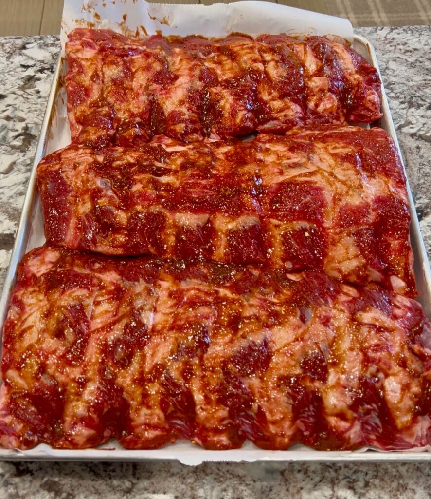 Adding the marinade all over the ribs 