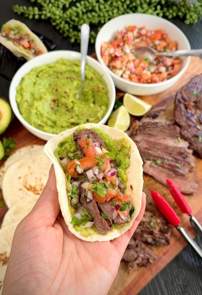 Serving steak tacos with guacamole and pico de gallo